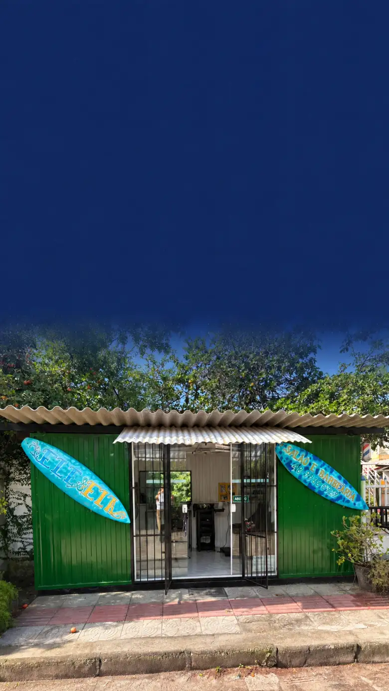Fachada do salão Ele e Ela, com parede verde e pranchas turquesa na entrada